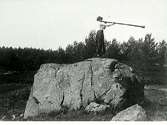 Kvinna som står på ett stenblock och tutar i näverlur från Dalarna.