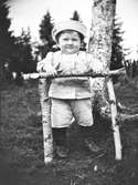 Sven, Hjärtum 1915-05-14 står och håller sig och poserar vid hemtillverkad ställning.