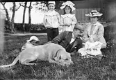 Carl och Elin Liljefors med barnen Carin, Olof, Ivar, och Signe och deras hund ute i trädgården i Sverige