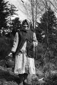 Ida från gården Kajeberg står i en skogsbacke och håller i en stor, sotig kopparpanna.