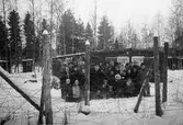 Estländska flyktingar i karantänläger hösten 1944. Familjerna står bakom en taggtråd som omringar det så kallade karantänlägret i Byringe, Örnsköldsvik. I lägren avlusades flyktingarna och de läkarundersöktes grundligt. Deras kläder och tillhörigheter brändes. Vid minsta sårbildning eller spricka i huden fördes flyktingarna till sjukhus. Rädslan för smittsamma sjukdomar var stor under rådande krig. Hösten 1944 flydde 32.000 estländare från kriget i Estland till Sverige. Ett sextiotal personer tog jobb på August Werners textilfabrik i Lindome. 
Kvinnorna arbetade i spinneriet och männen i färgeriet. 
Mer information finns i uppsatsen 