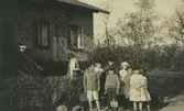 Gruppfoto utanför Franska byggena. Målar-pelle bodde under en period i huset.
Personer: H Bergschöld, Helge Johansson, Edvin Lowndes, Åke Nordqvist, Sigrid Andersson, Berta Lowndes, Margit Andersson, Berta Andersson.