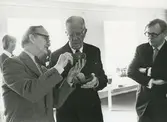 Kungligt besök på Gustavsbergs porslinsfabrik. Stig Lindbeg förevisar stengods, sannolikt i Gustavsbergs Studio.
Personer: Kung Gustav VI Adolf,  Stig Lindberg, Arthur Hald.och Lisbeth Enzell.