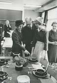 Interiörbild. Invigning av Stockholms stads nya yrkesskola på Kungsholmen. Närvarande: Kung Gustav VI Adolf och drottning Louise,<br>Dukning med hushållsporslin från Gustavsbergs fabriker.
Personer: Kung Gustav VI Adolg, drottning Louise och okända peroner.