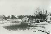 Exteriör. Tvättstugan vid Bagarns träsk, Gustavsberg. Riven i samband med byggnationen av Runda huset 1953 strax intill. T.v. Klubbhuset och t.h. Bageriet.