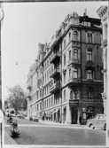 Hörnhuset Drottninggatan-Tegnérgatan före rivningen. Fasaden mot Tegnérgatan. I fonden skymtar Tegnérlunden. I hörnet Aspingtons välkända antikvariat. Foto 1959.