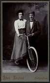 En kvinna och en man vid en cykel.