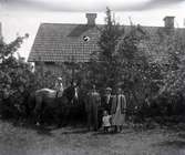 August Jonsson med flera i Kåtorp. Ett barn sitter på en häst.