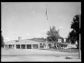 Bussgarage i Enebyberg tillhörandes Stockholm - Roslagens Järnvägar/Stockholms Läns Omnibus. Byggnaden innehöll bussgarage, tvätthall, gummiereparationsverkstad och bensinstation.