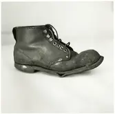 Skyddsskon som bars av personvagnsreparatör Einar Larsson, vid Trafikaktiebolaget Grängesberg–Oxelösunds Järnvägars järnvägsverkstad i Eskilstuna, och som räddade hans tår i samband med en arbetsplatsolycka då en 150 kilos buffert föll ner på hans fot.