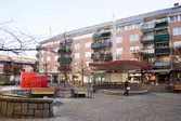 Mölndals torg 2-4 (Havskatten 17), år 2015. Bild 1: torget med Bergmansgatan till höger. På torget finns en scen, bänkar och en röd lekborg för barn. Bild 2: butiker. Bild 3-4: nordost mot Bergmansgatan. Bild 5: Ronnix shoes med entré mot torget. Dokumentation av platsen innan rivning och nybyggnation.