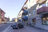 Bergmansgatan 18-24 västerut, år 2015. Några bilar står parkerade utanför Café Kaffebubblan. I bakgrunden ser man den korsande Storgatan samt Frölundagatan som fortsätter rakt fram. Relaterade motiv: 2018_0156. Dokumentation av platsen innan rivning och nybyggnation.
