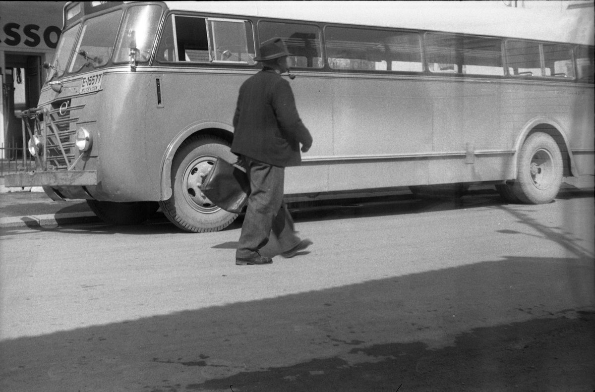 En buss og en uidentifisert fotgjenger foran Esso bensinstasjon på Lena, mai 1953.
Bussen er ifølge informant en Volvo B513 med karosseri påbygd ved Gjøvik Støperi. Den tilhørte først Hans Aske i Vardal. I 1951 ble den overtatt av nystartede A/S Vestre Toten og Land Bilruter, og i 1953 av Kolburutene. (Foto/Photo)