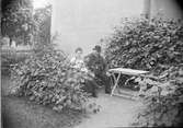 Emma Osti och man i trädgården, Bredgränd 11, Uppsala före 1914