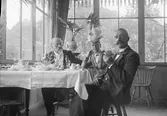 Sällskap vid frukostbord, sannolikt Ostis ateljé, Uppsala före 1914