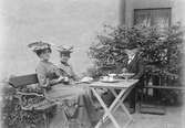 Emma, Henri Osti och kvinna i trädgården, Bredgränd 11, Uppsala efter 1893