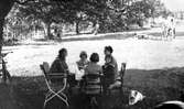 Midsommar med kaffebord i trädgården i Nästa by, Värnamo. Kring bordet sitter Julia Fredricsson, Birgitta, Inger, Gertrud Fredricsson och en okänd dam till höger.