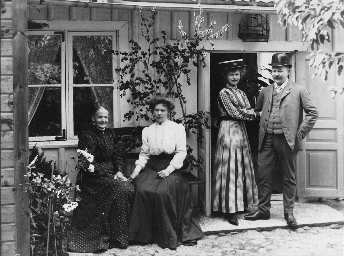 Calla Helena Sundbeck, The Allard family in the courtyard of Bergsgatan 4. On the bench sits the wagon gang Mathilda Allard and the daughter Velis. In the door stand the other children Hedvig (Mimmi) and Gustaf. Above the door hangs a bird cage
