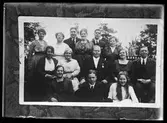 Reprofotografi av en gruppbild på ett antal män och kvinnor i olika åldrar. I fotografens egna anteckningar står det 