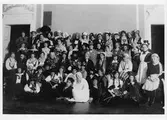 Gruppbild tagen på Stadshotellet med ett 60-tal kvinnor, i olika åldrar, i maskeradutstyrslar.