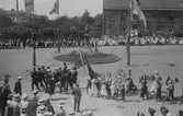 Stora Torget i Alingsås 2 juni 1911, människor i olika paradformeringar högtidlighåller Jonas Alströmers dödsdagsom var den 2 juni 1761.