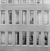 Detalj av fasaden mot Drottninggatan. Såsom fasadklädnad har använts grå-brun-röd kullagranit. Utvändigt är fönsteromfattningarna klädda med eloxerad aluminium.