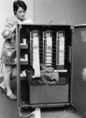 Här ses det sinnrika innanmätet på en av de tolv s.k. proofmaskinerna - IBM 802 - med ett fack och en räkneremsa för resp. bank. Det är Gerd Andersson som granskar en remsa.