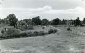 Karbenning sn, Hästbäck.
Vykort med Hästbäck från väster, 1950-talet.
Byggnader och landsväg genom landskapet.