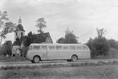 Okänd buss. Karossen tillverkad av Aktiebolaget Svenska Järnvägsverkstäderna, ASJ. Leveransfoto. Vreta kloster i bakgrunden.