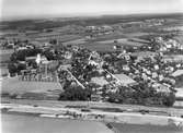 Flygfoto över Dalby. Längst fram i bild syns järnvägsstationen. Till vänster syns Dalby kyrka.