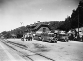 Statens Järnvägar, SJ bussar och lastbilar vid Dingle järnvägsstation. Bland bussarna syns bland annat SJ 5, byggd 1923 och slopad 1934. Järnvägsstationen uppfördes av SJ 1905.