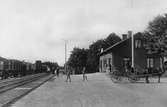 Emmaljunga järnvägsstation. Bilden troligen tagen på 1930-talet då äppelknyckarbyxorna, som bärs av pojken mitt i bilden, var högmoderna.
Häst med vagn till höger i bild.