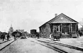 Provisoriska stationshuset. 
Till vänster, nya stationshuset och banhall under uppförande.