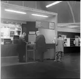 Herrar samt dam som nyttjar postkontoret kopplat till Järnvägsstationen vid utställningen i Göteborg 1962.