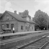 Åsbro station. Trafikplatsen öppnades 1874 av Hallsberg - Motala - Mjölby Järnväg, HMMJ.  Övergick till SJ 1879. På bilden syns stationskarl som visar tecken för saktakörning.