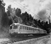 Statens Järnvägar, SJ X0a5. Motorvagnståg, linjen Ctockholm -Ses. Tunnel i bakgrunden, alltså är bilden tagen vid Tullinge eller Rönninge. X0a5  hade högsta hastighet av 94km/h och blev Sveriges snabbaste tåg på helsträcka. I drift fram till mitten av 1980-talet.