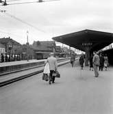 Perrongen på Eslöv järnvägsstation. Elektrisk drift installerades 1933. Förekomsten av militärer bland de resande gör det troligt att bilden är tagen under krigsåren. Till vänster syns ett flertal bussar av 1930-tals modell. Till vänster skymtas också Stadshotellet.