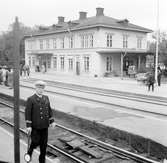 Köpings station öppnad för trafik 7 dec 1875. I förgrunden går en stins.