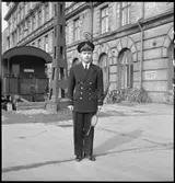 Tågklarerare med signalstav, mörk uniform.