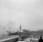 Statens Järnvägar SJ 1856-1956. 100-årsjubileum. Tåg med gamla lok och vagnar på järnvägsbron mellan Mälarstrand, och Riddarholmen