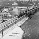 Statens Järnvägar SJ 1856-1956. 100-årsjubileum.Tåg med gamla lok och vagnar på Södra Järnvägsbron på sträckan mellan Riddarholmen och Mälarstrand..