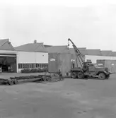 Lossning av helikopter i emballage från låglastande släpvagn, vagnbjörn