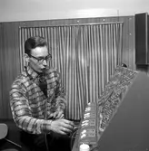 A.G. Nydell  eller G. Rydergren, vid kontrollerna till en modelljärnväg, uppförd inuti en tågvagn