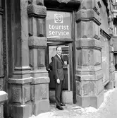 Statens Järnvägar SJ turistbyrå. Förste Byråsekreterare, Fbrs, S Törneheim poserar framför entrédörren.