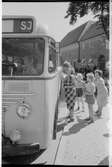 Resande vid busshållplats. Påstigning på buss. Statens Järnvägar, SJ-buss.