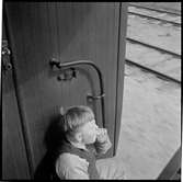 En pojke sitter vid ingången till ett tåg.