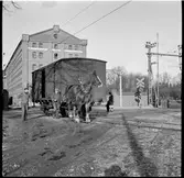 Arbetshäst drar godsvagn vid en järnvägsövergång.