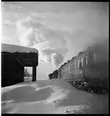 Persontåg vid en snötäckt hållplats.