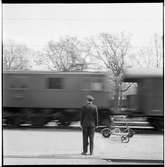 Stationsinspektor med signalstav vid passerande tåg.