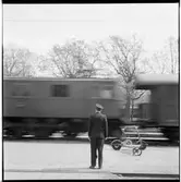 Stationsinspektor med signalstav vid passerande tåg.